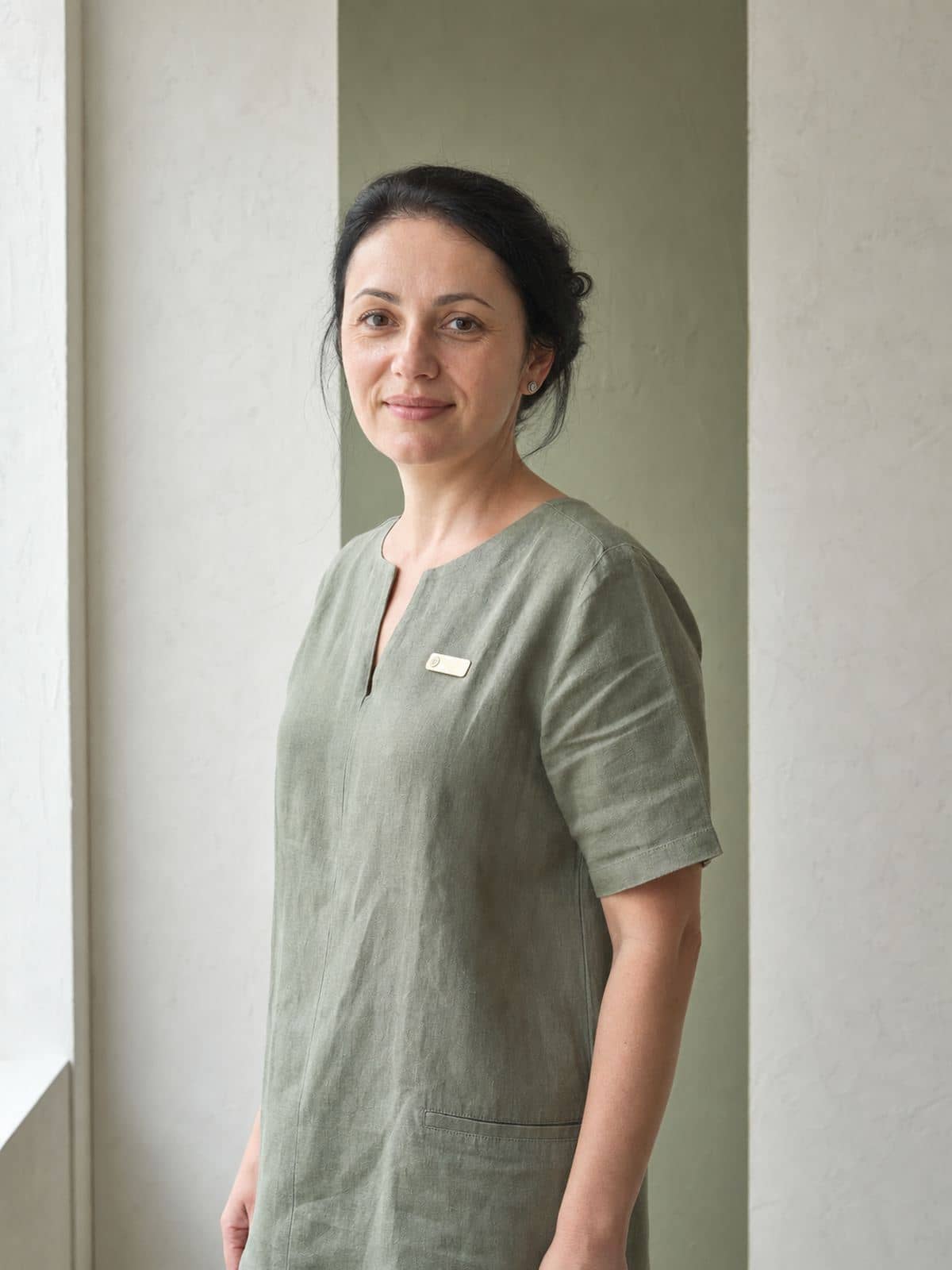 Medic stomatolog din echipa Dentaire Verde în tunică sage